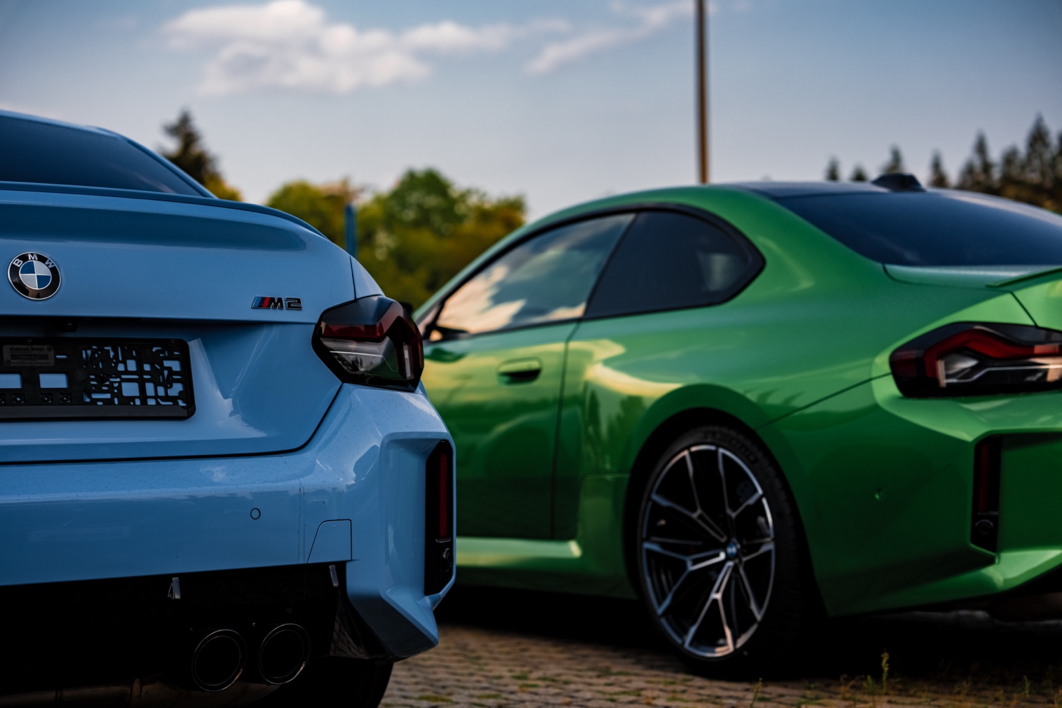 Zwei BMW M2 in Blau und Grün nebeneinander