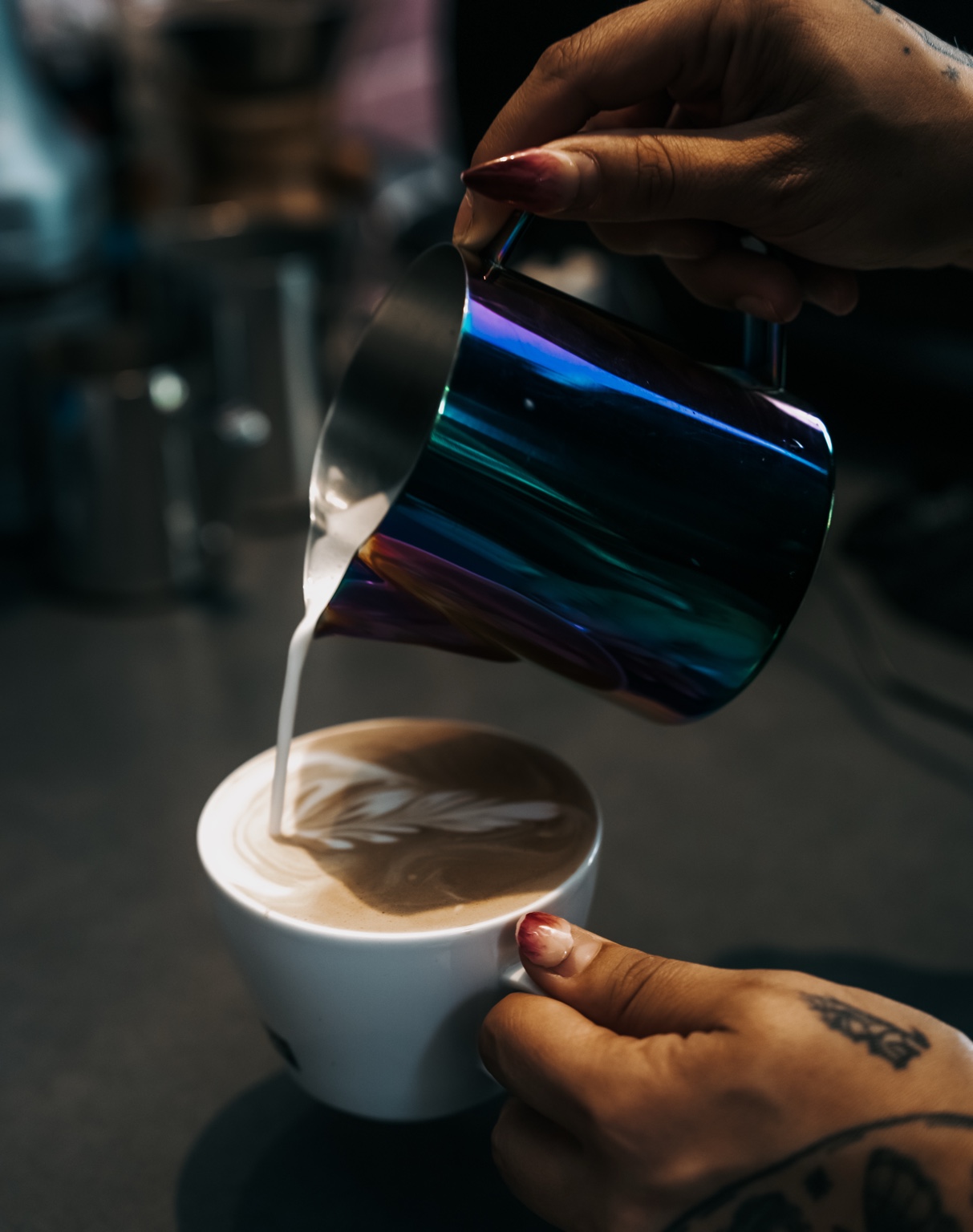 Barista gießt Latte Art in eine Kaffeetasse
